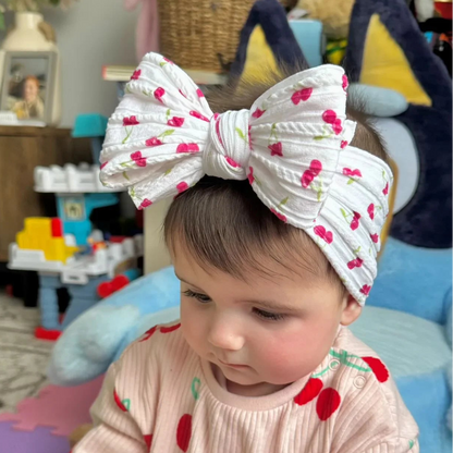 White Cherry Print Larger Bow Headband For Newborns to Age 3 - Image 1